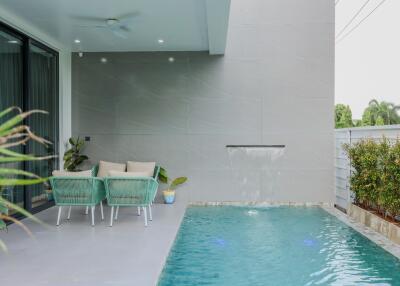 Patio area with two chairs and a swimming pool