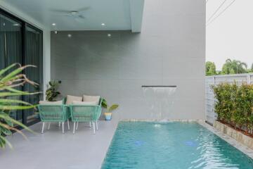 Patio area with two chairs and a swimming pool