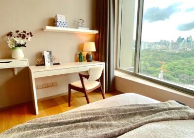 Bedroom with desk area and large window with city view