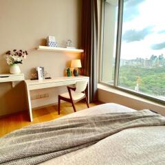 Bedroom with desk area and large window with city view