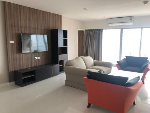 Modern and spacious living room with furniture, TV unit, and large windows