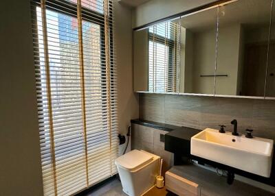 Modern bathroom with large window, blinds, and a floating sink