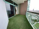 Spacious balcony with artificial grass flooring and a panoramic city view