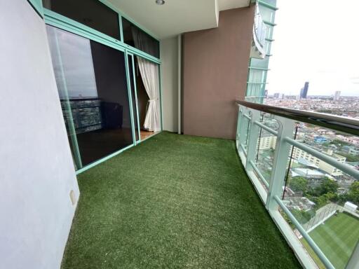 Spacious balcony with artificial grass flooring and a panoramic city view