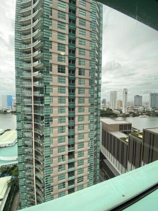 View of a high-rise building from a window showing city skyline and river