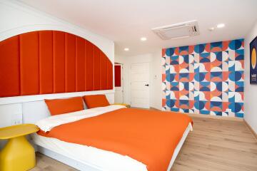 Bedroom with colorful geometric accent wall and modern decor