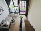 Modern living area with loft-style staircase and large window with city view