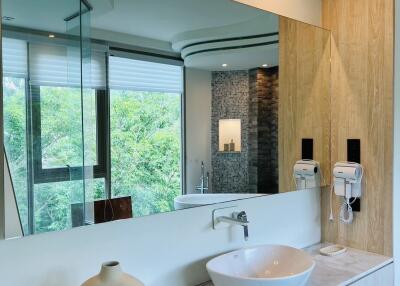 Modern bathroom with large mirror, washbasin, and window view