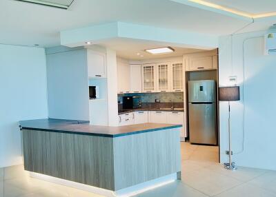 Modern kitchen with white cabinets and stainless steel refrigerator