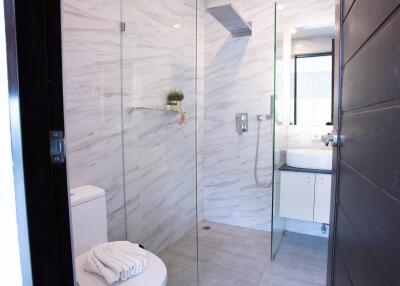 Modern bathroom with glass shower enclosure and white fixtures