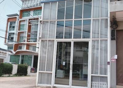 Front facade of a commercial building with large glass windows and door