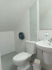 Small bathroom with toilet, sink, and mirror