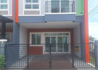 Front view of modern townhouse with balcony and gated driveway