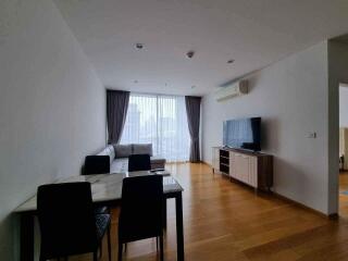 Modern living room with a sofa, dining table, and a TV