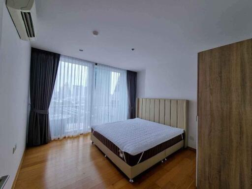 Spacious and bright bedroom with large windows and double bed