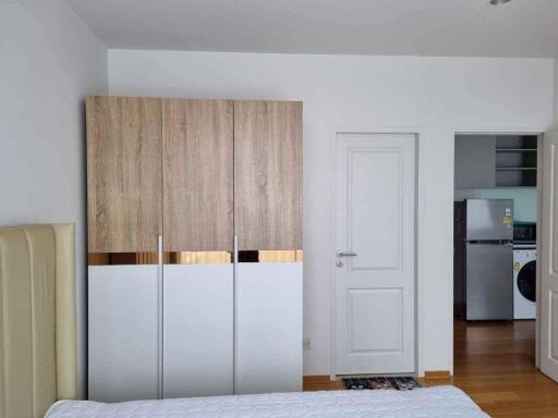 Modern bedroom with wardrobe and view into adjacent kitchen