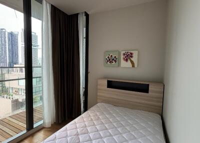 Small bedroom with a bed and large windows with a city view