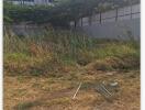 Vacant land with overgrown grass and fencing