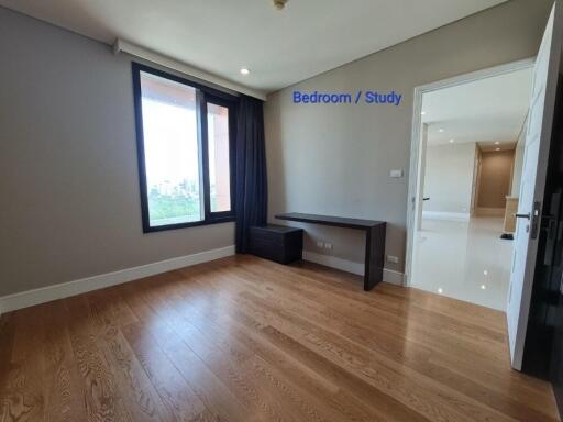 Bright bedroom or study with wooden flooring and large window