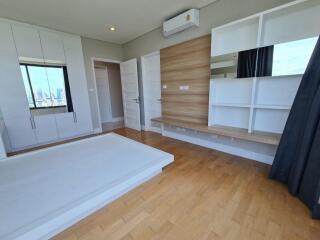 Modern bedroom with wooden flooring and built-in storage