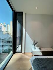 Bedroom with large glass window and city view