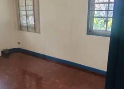 Empty bedroom with polished wood floors and windows with blinds