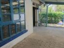 Covered outdoor patio with blue-framed windows