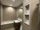 Modern bathroom with glass shower, bathtub, and toilet