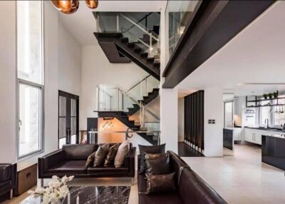 Modern loft-style living space with open kitchen and staircase