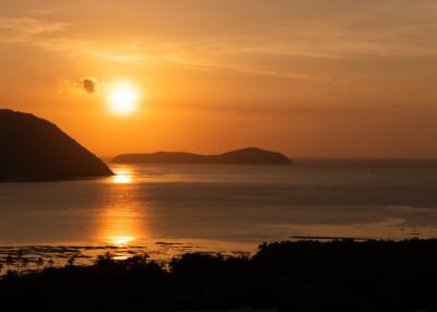 View of sunset over a body of water with hills in the background