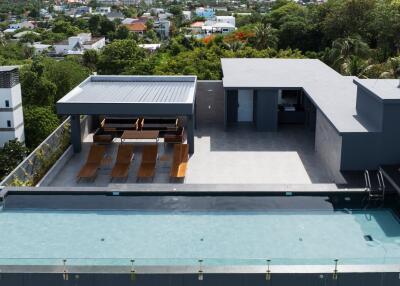 Rooftop amenities with pool, lounge chairs, and covered seating area