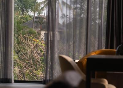 Living room with a scenic view through sheer curtains