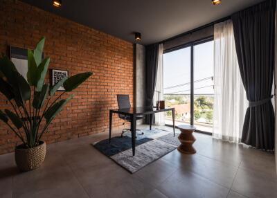 Modern home office with brick accent wall and large window