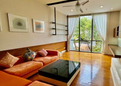 Living room with modern decor, large windows, and wooden flooring