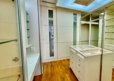 Spacious walk-in closet with ample storage and glass display case