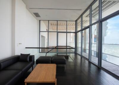 Spacious modern living room with floor-to-ceiling windows and balcony