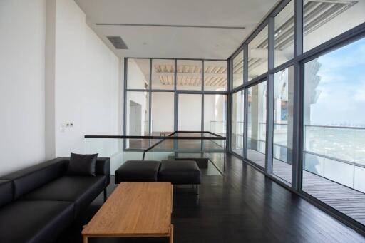 Spacious modern living room with floor-to-ceiling windows and balcony