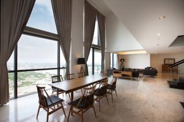 Spacious living and dining area with large windows and modern furniture