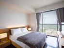 Well-lit bedroom with large window and city view