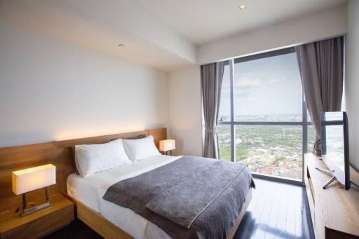 Well-lit bedroom with large window and city view