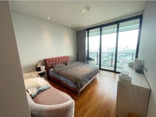 Bedroom with a bed, couch, large windows and city view