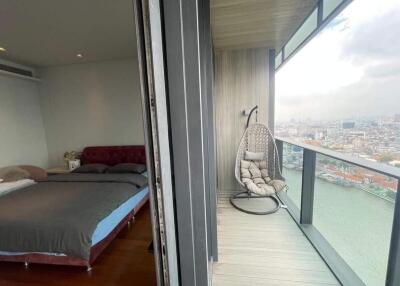 Modern bedroom with glass door leading to a balcony overlooking the city