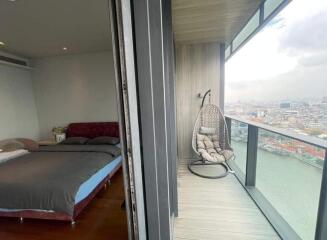 Modern bedroom with glass door leading to a balcony overlooking the city