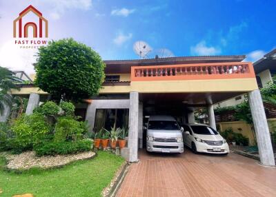 Exterior view of a residential building with two cars parked in the driveway