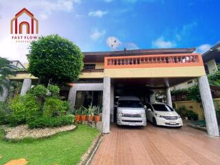 Exterior view of a residential building with two cars parked in the driveway