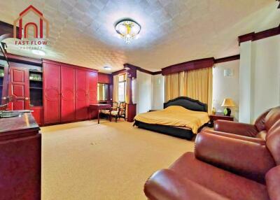 Spacious master bedroom with red cabinetry and comfortable seating