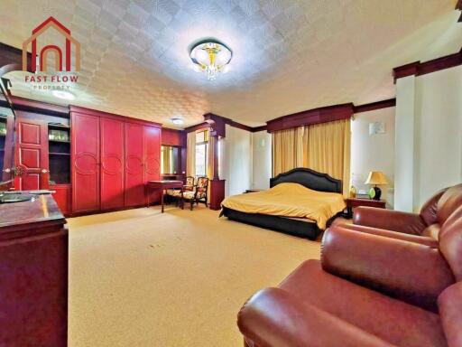 Spacious master bedroom with red cabinetry and comfortable seating