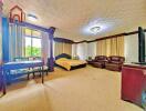 Spacious master bedroom with large windows, bed, seating area, and television