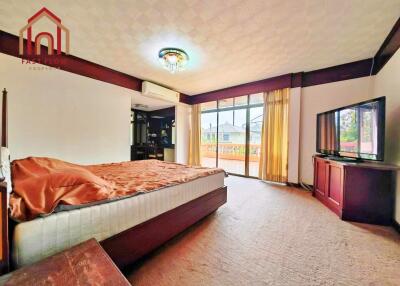 Spacious bedroom with a large bed, balcony access, and ample natural light