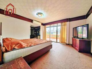 Spacious bedroom with a large bed, balcony access, and ample natural light